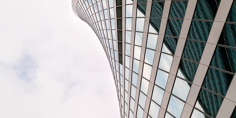 Angled view of modern skyscrapers in business district against blue sky