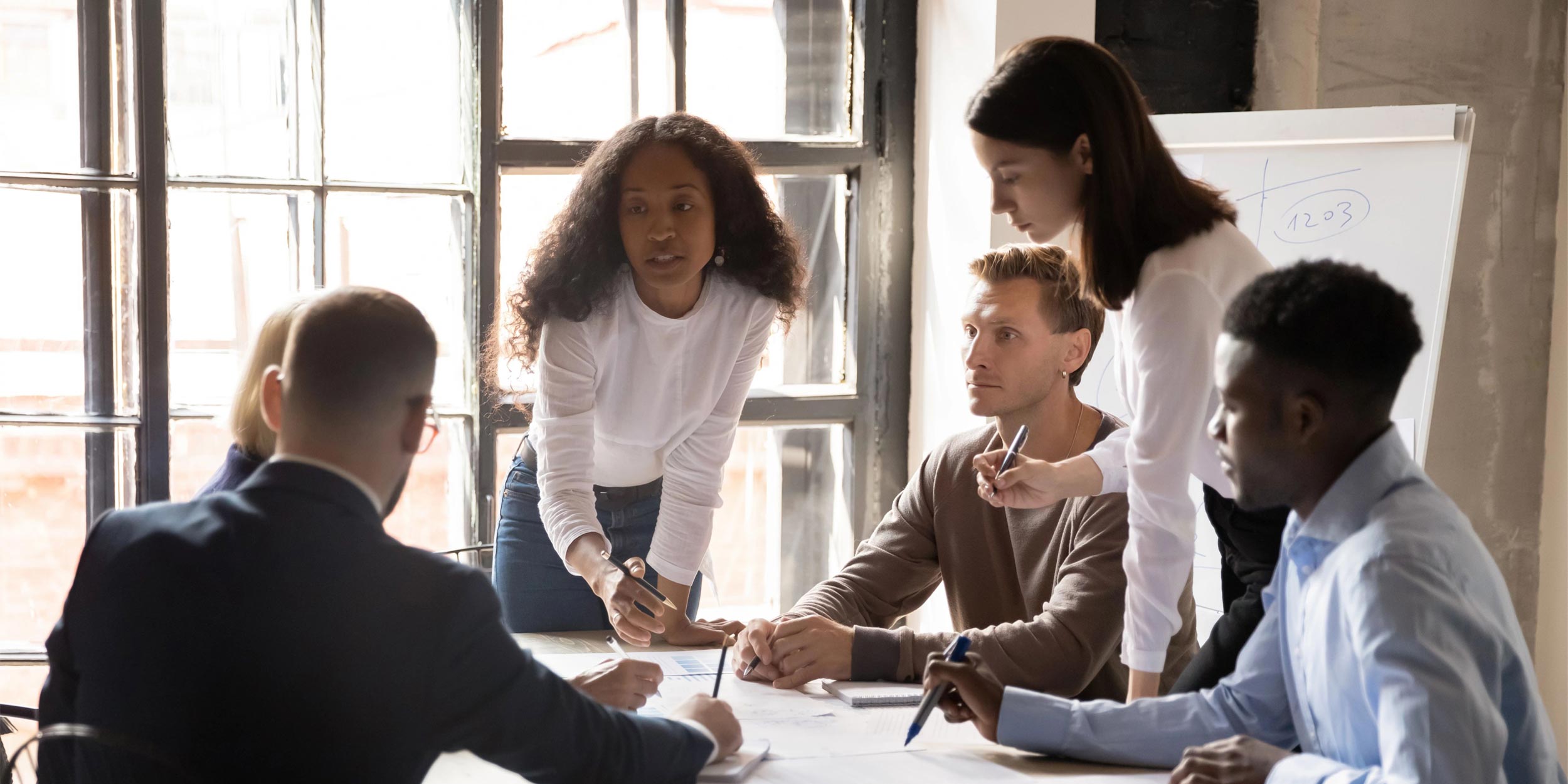 Diverse colleagues working on project together, sitting at table