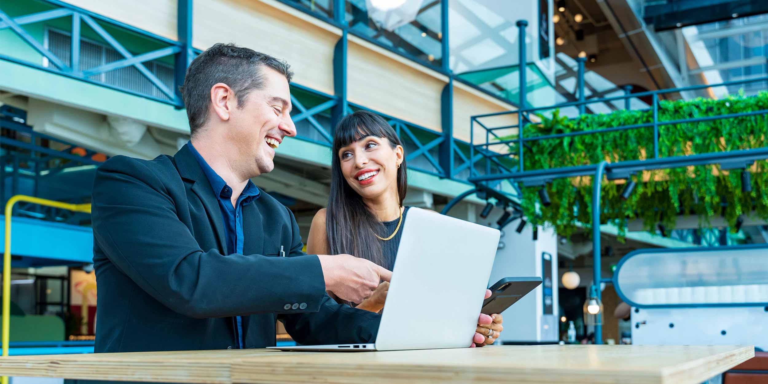 Businessman and businesswoman looking at the report from laptop