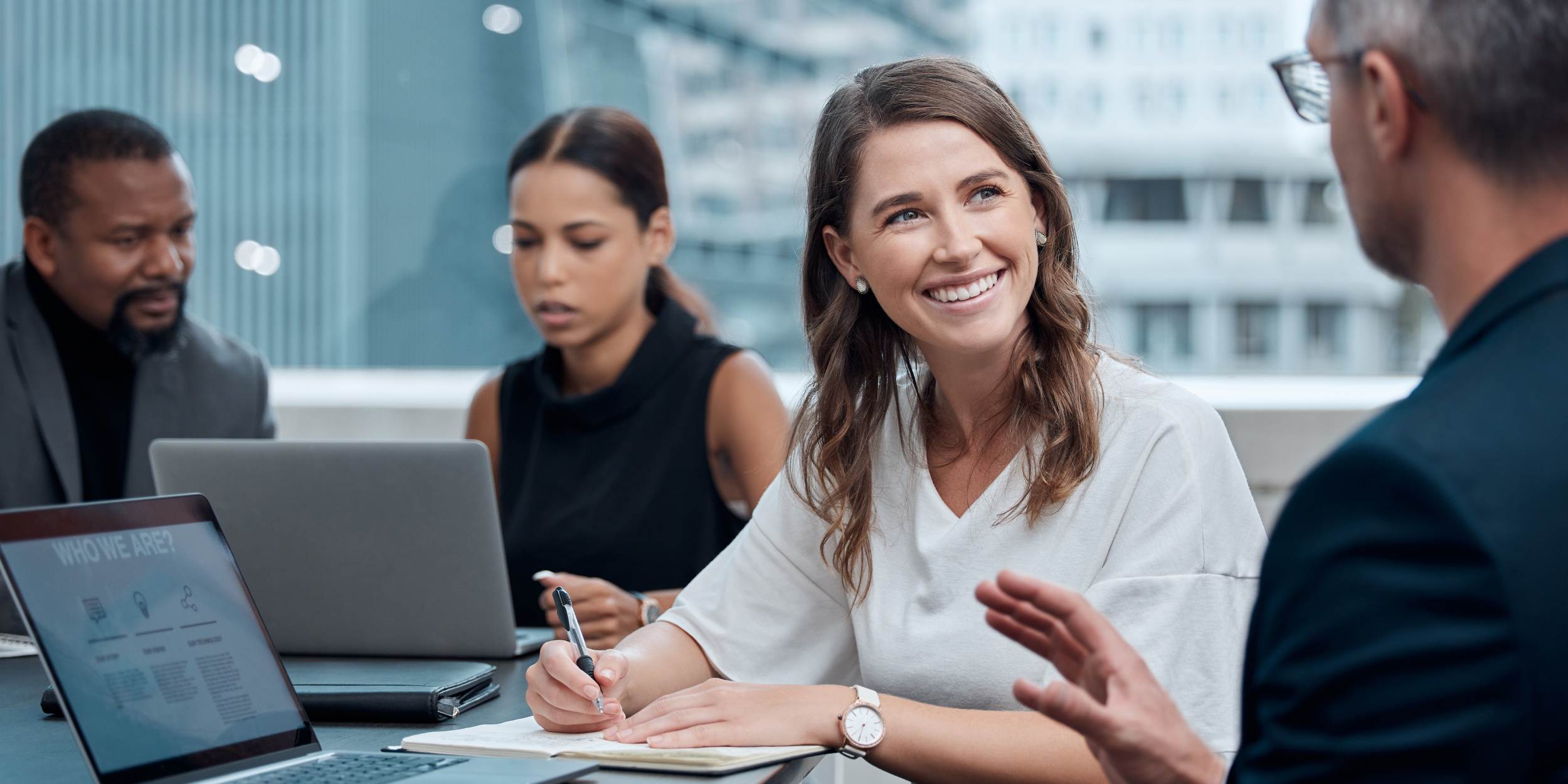 Team meeting with laptops and notes.