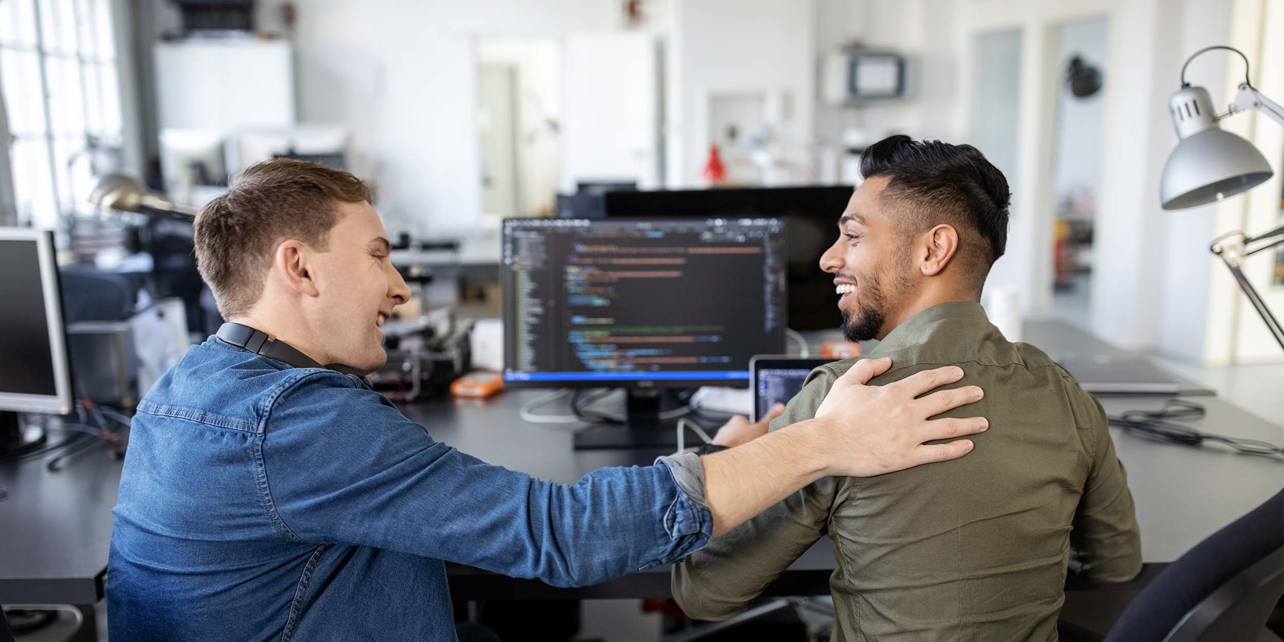 Two web designers working on a project looking happy with the progress