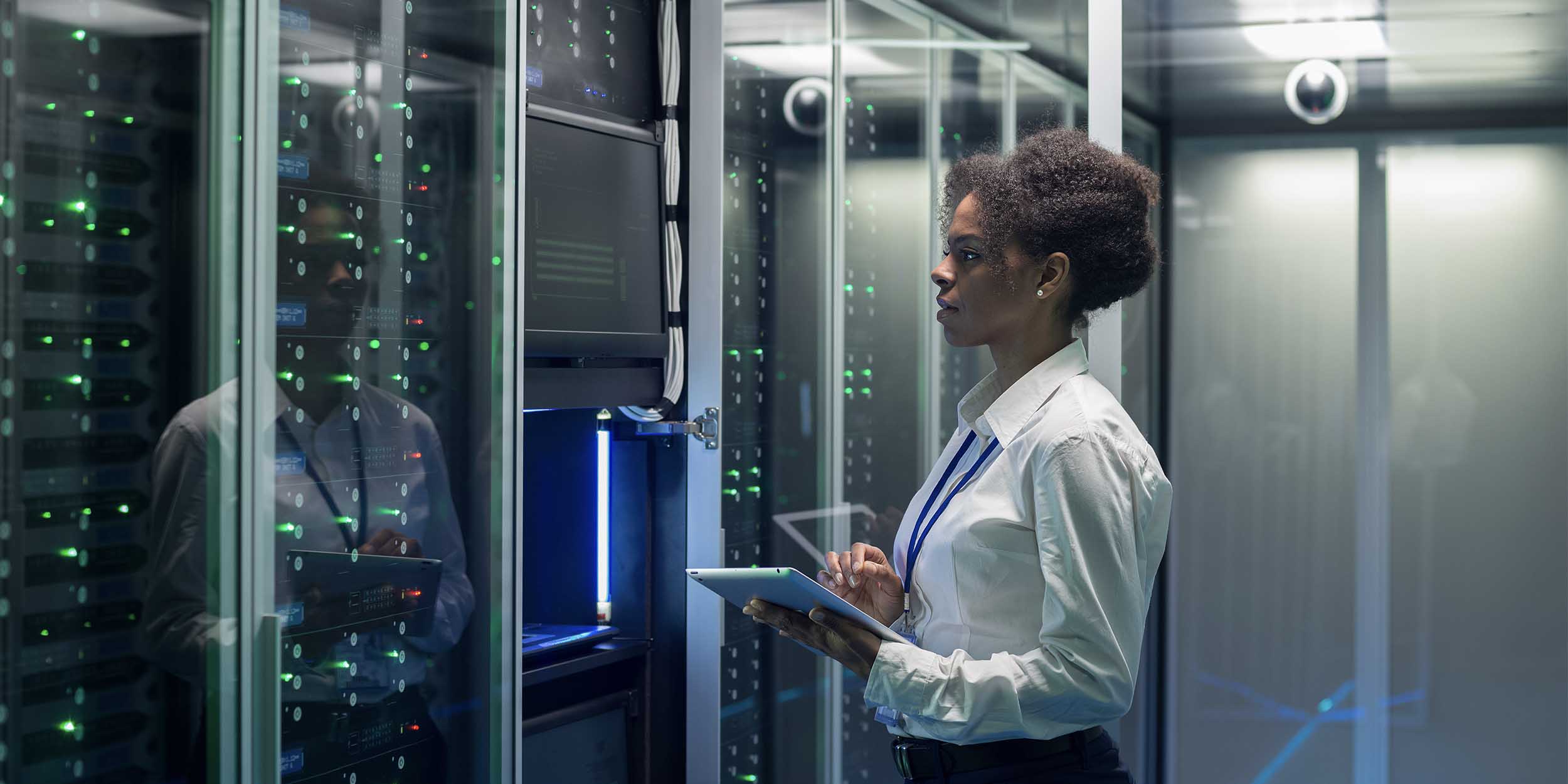 Female technician works on a tablet in a data center