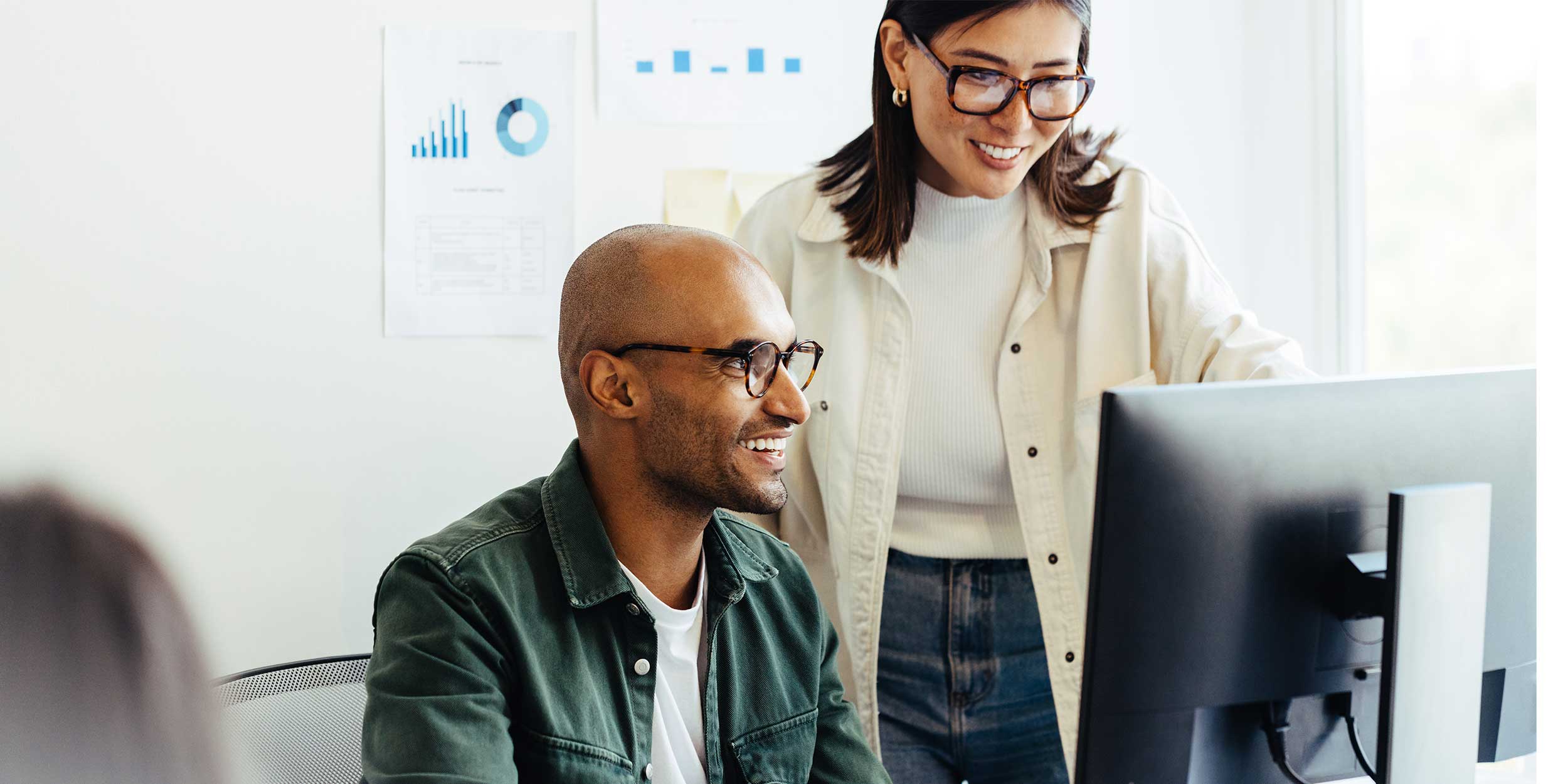 Two colleagues looking at a computer screen together 