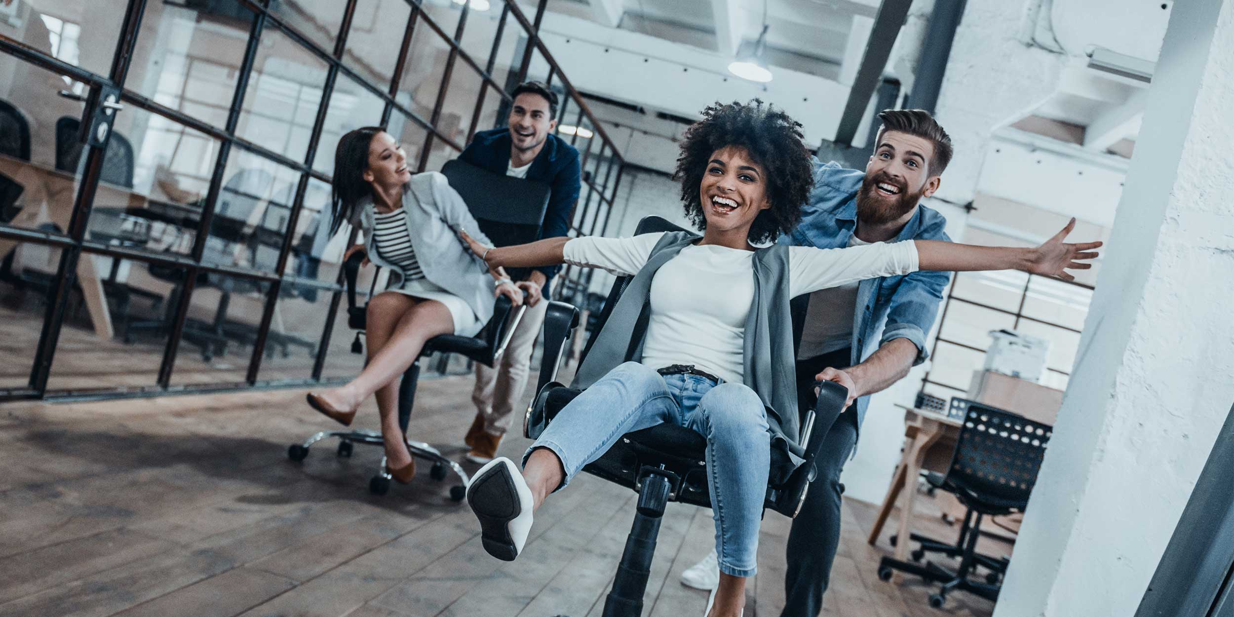people in the office racing on chairs