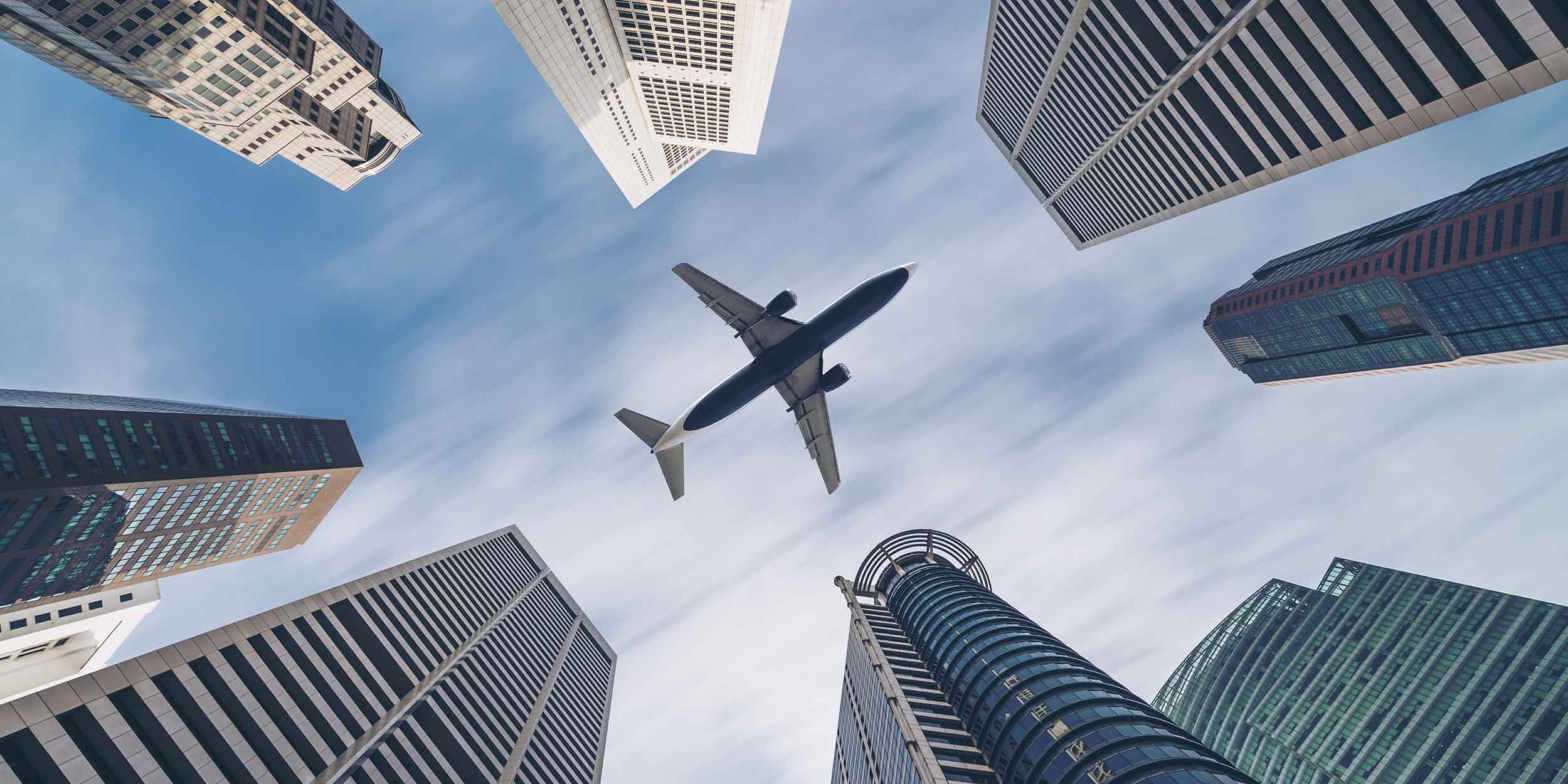 plane flying over buildings