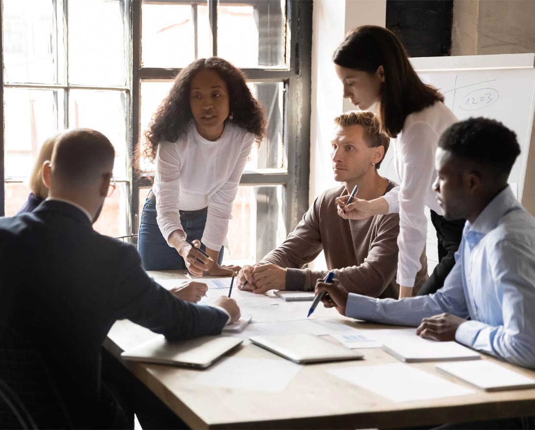 Diverse colleagues working on project together, sitting at table