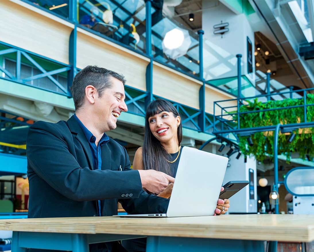 Businessman and businesswoman looking at the report from laptop