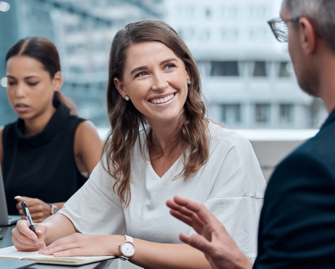 Team meeting with laptops and notes.