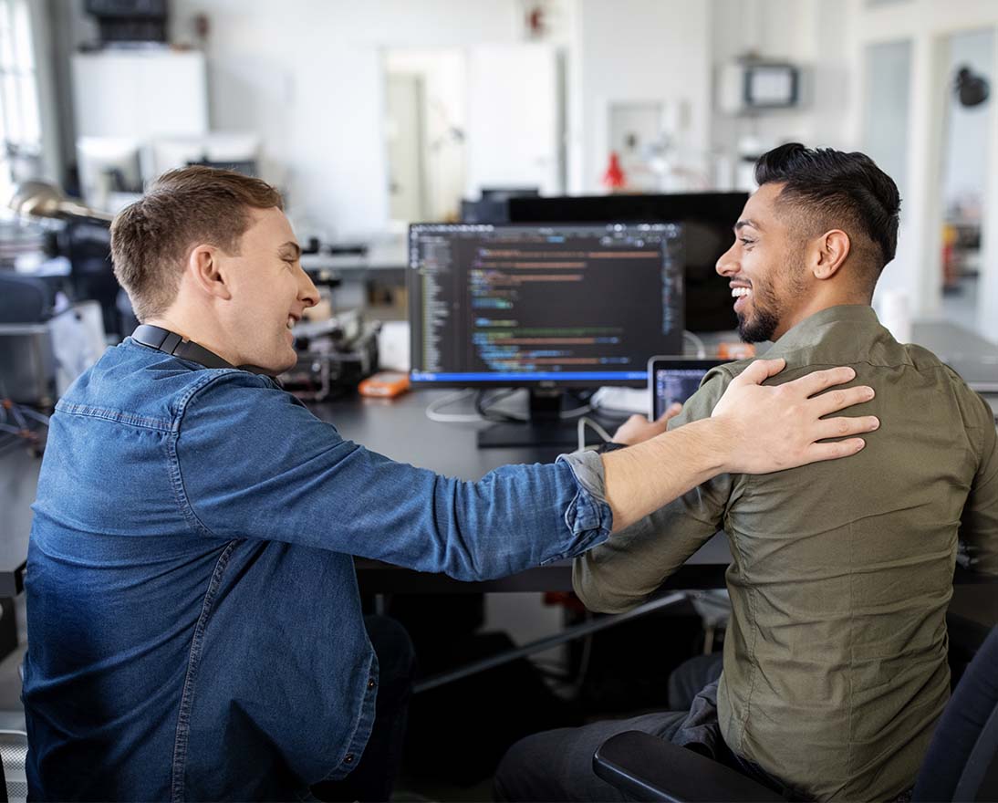 Two web designers working on a project looking happy with the progress