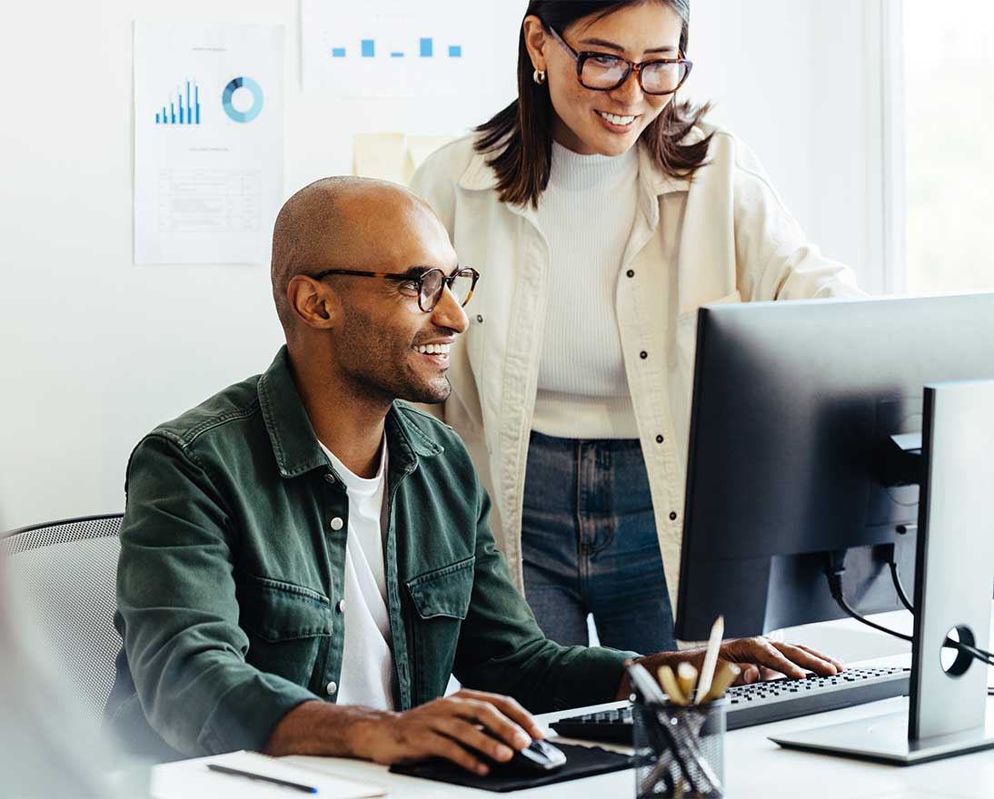Two colleagues looking at a computer screen together