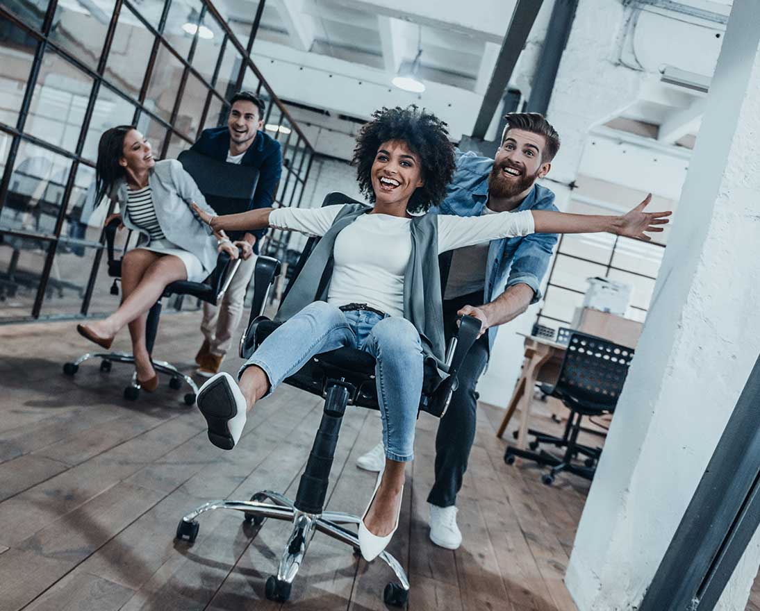 people in the office racing on chairs