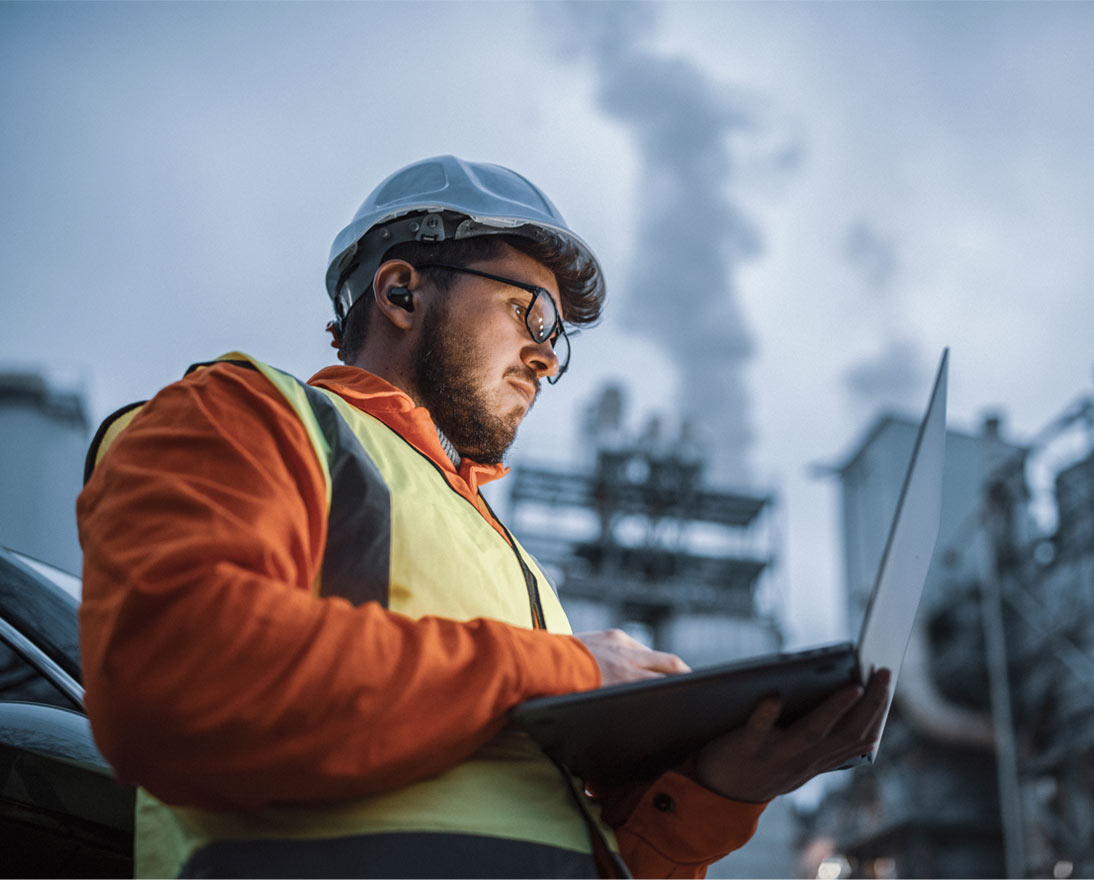 An engineer using a laptop while working in the oil and gas industry