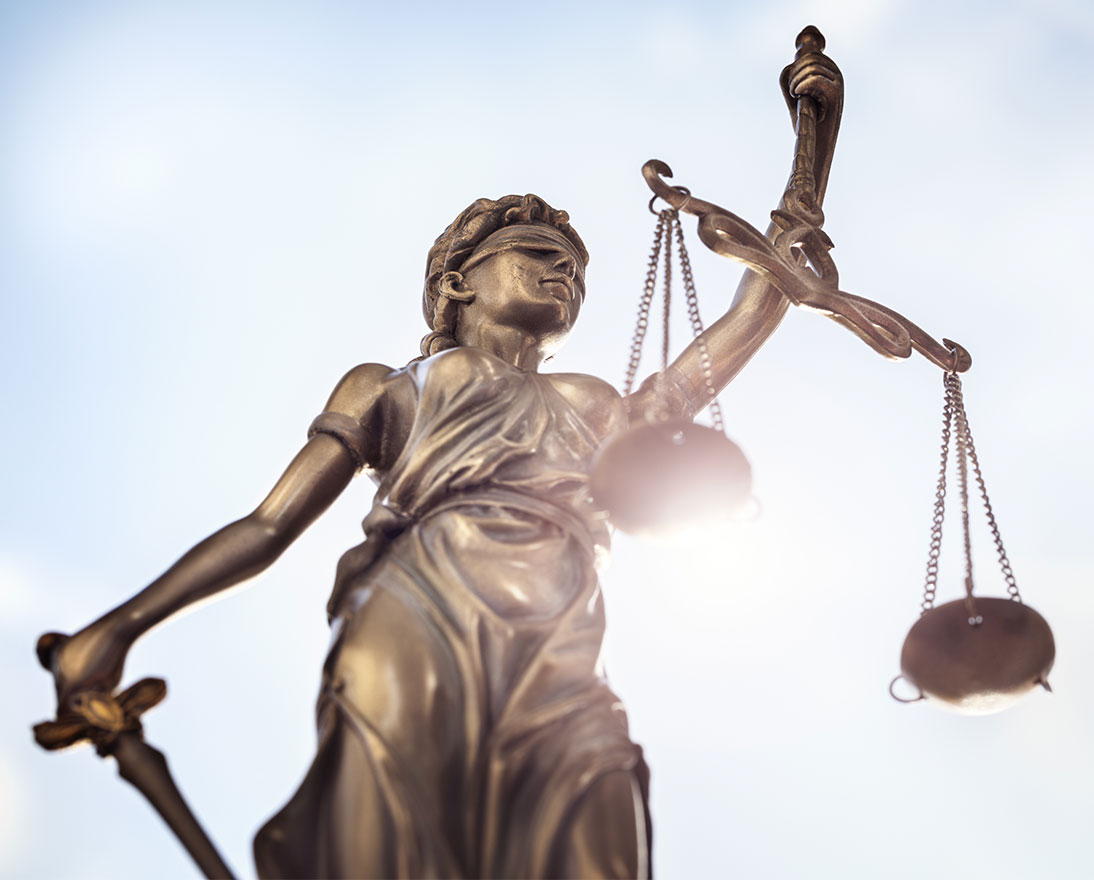 Legal law concept statue of Lady Justice with scales of justice sky background