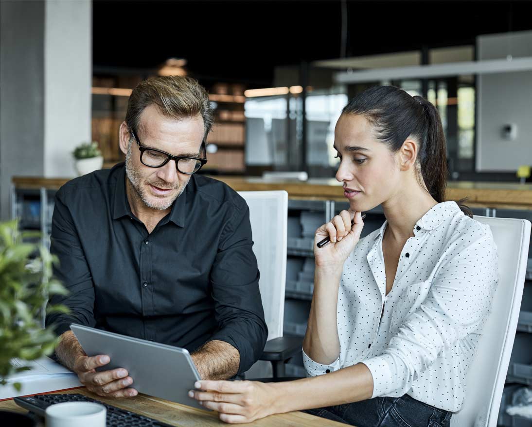 Male and female colleagues looking at tablet