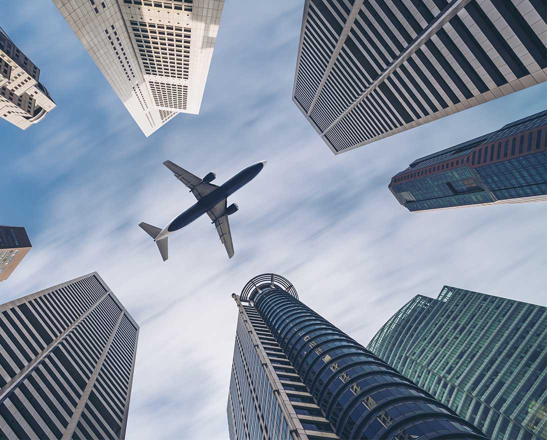 plane flying over buildings