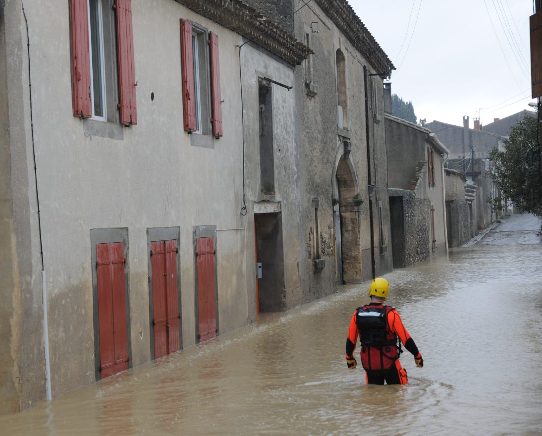 Rescuer walking through flooded street.