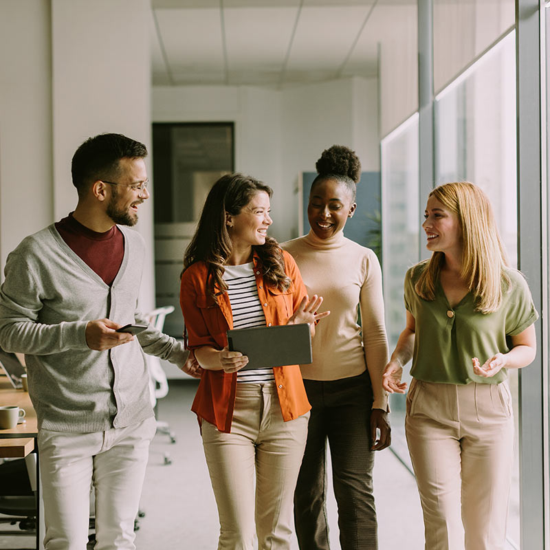 Four colleagues walking through an office together