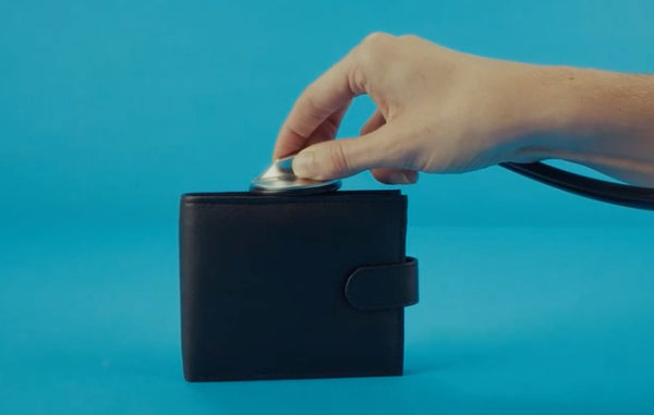 Hand putting coins into a wallet