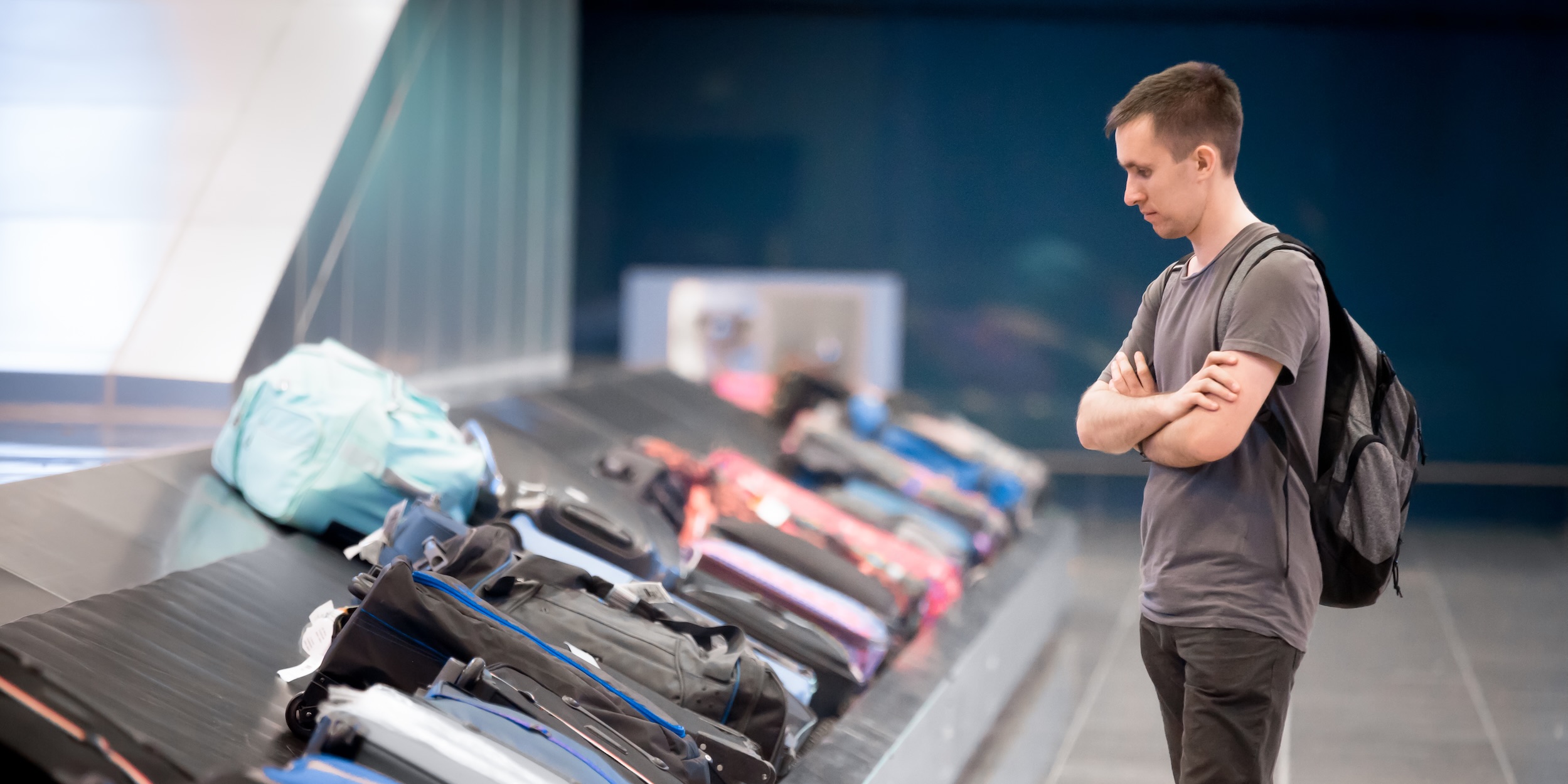 Man waiting at conveyor belt to pick his luggage