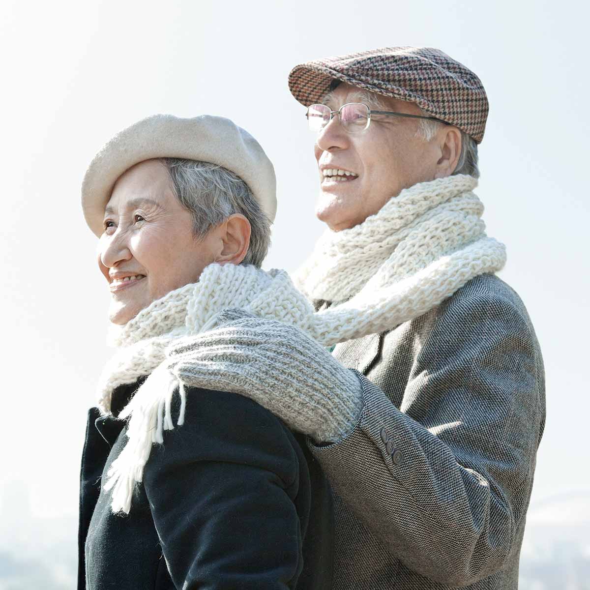 Close-up Of Happy Senior Couple In Warm Clothing Looking Away