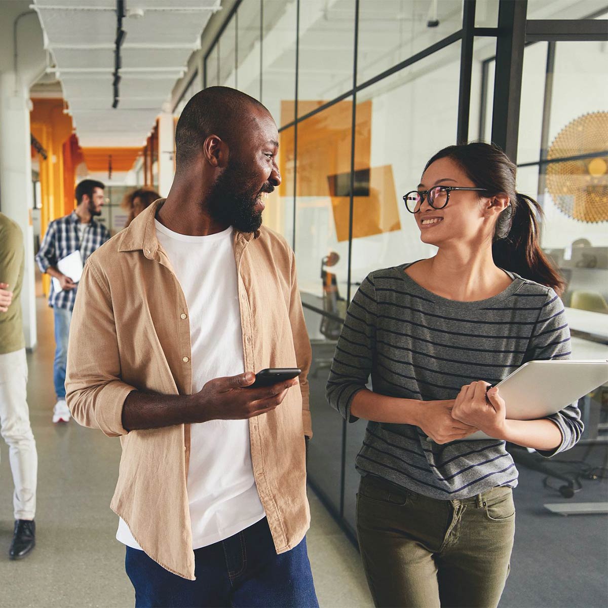 Two colleagues walking through the office together