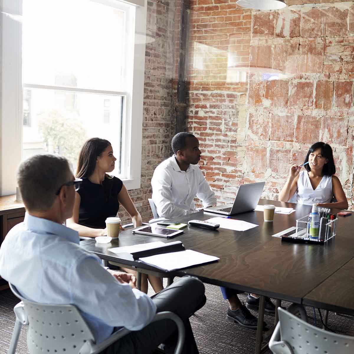 Group Of Businesspeople Meeting In Modern Boardroom