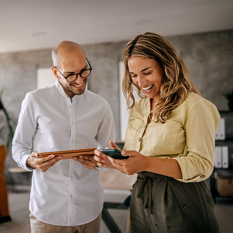 two people looking at their tablet and phone