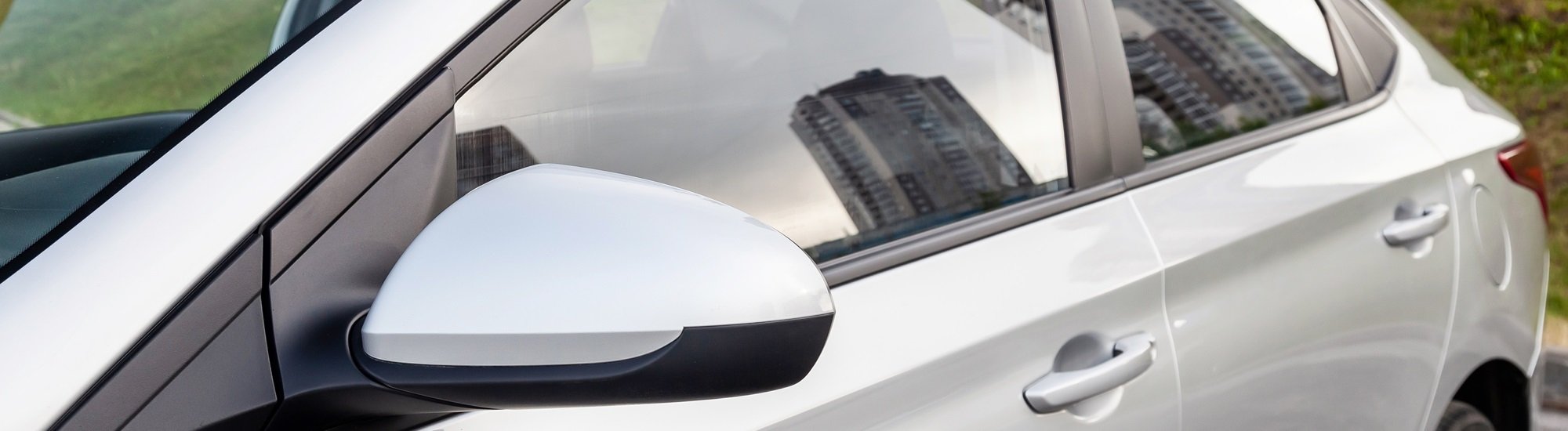 closeup of silver vehicle with cityscape in window