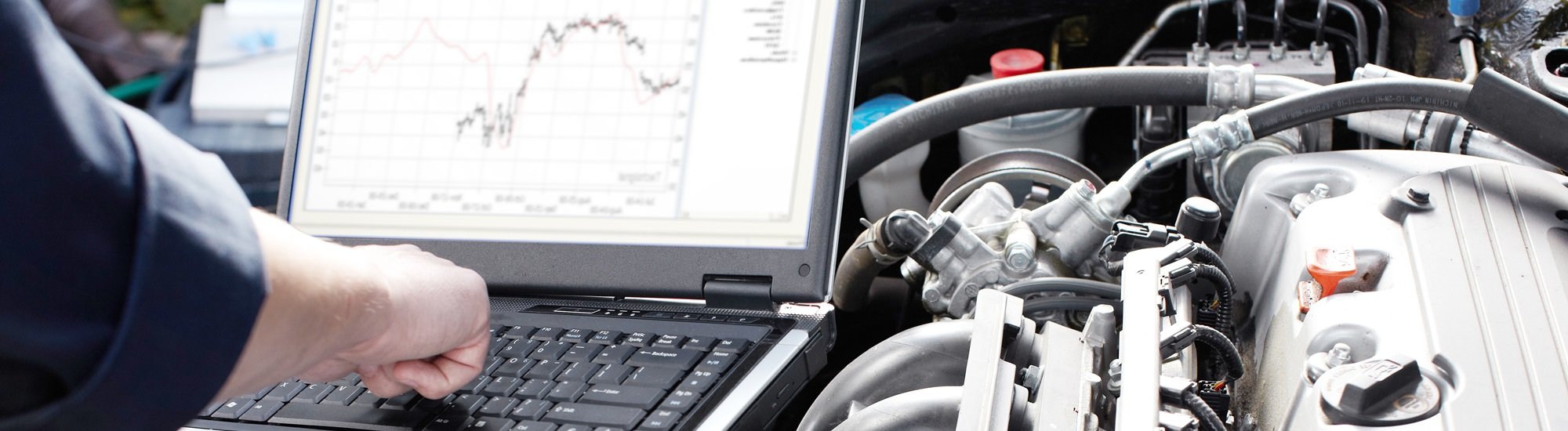 Man doing diagnostics on an engine with a computer