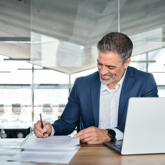 professional signing paperwork at office desk