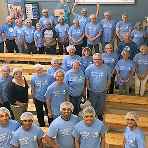 Group of volunteers in blue shirts posing together