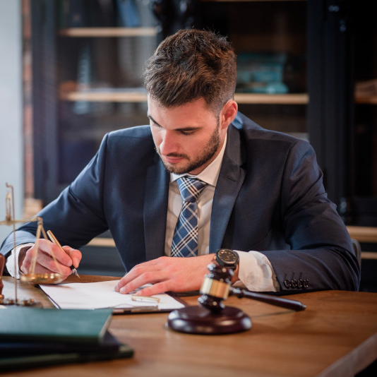 legal professional signing document at desk
