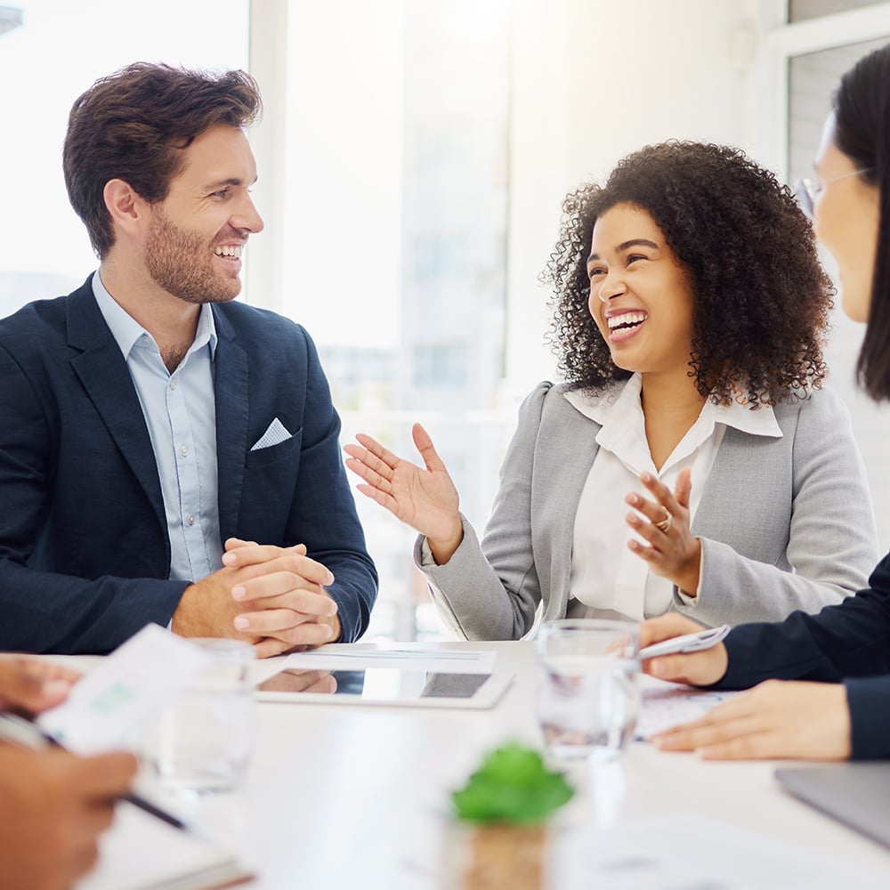 two people in a meeting room laughing