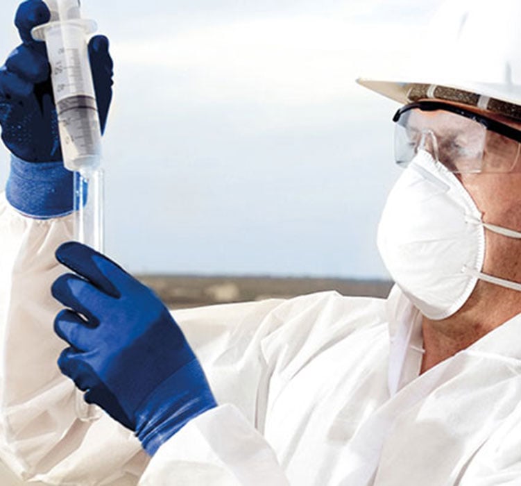 man in hazmat suit with mask and syringe