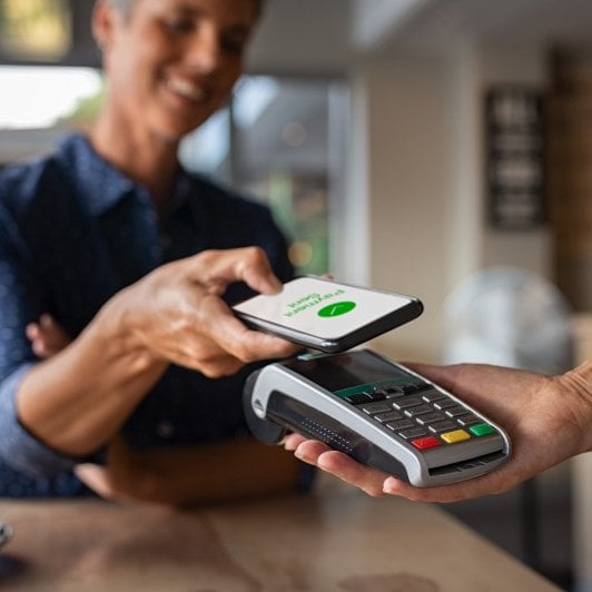 Customer pays with smartphone at retail store.
