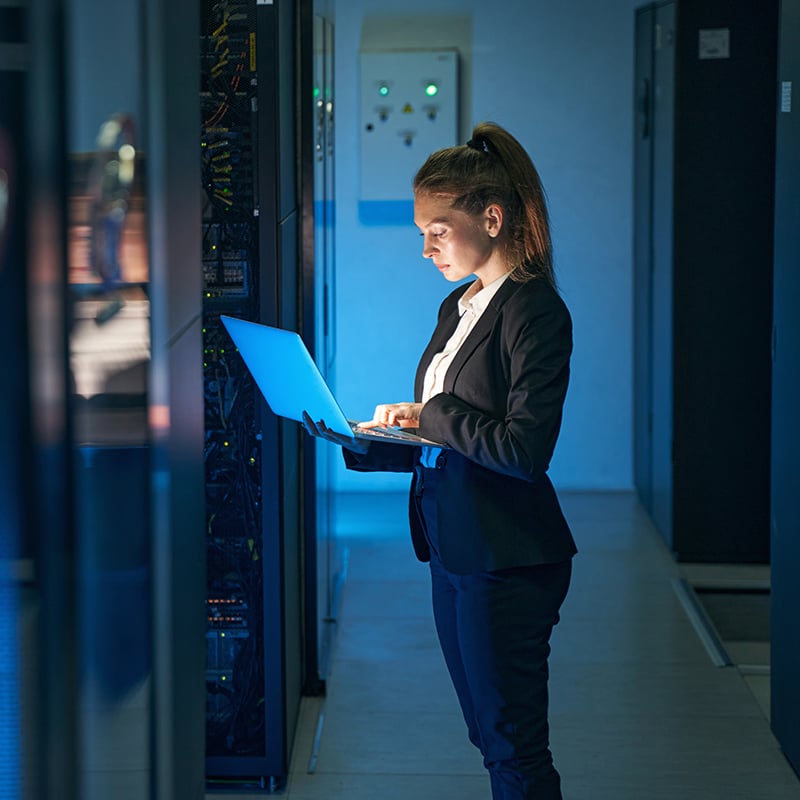 woman with laptop in server room