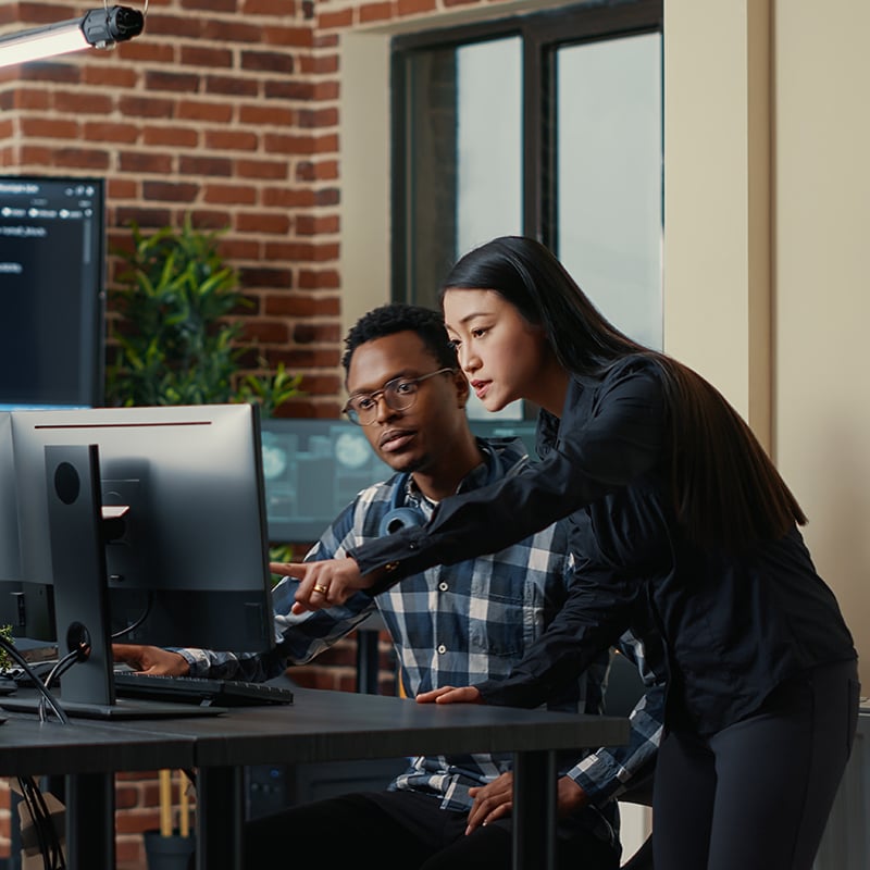 a man and woman talking in front of a computer