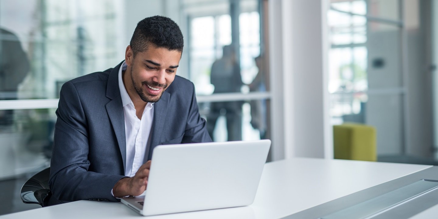 smiling man with a laptop
