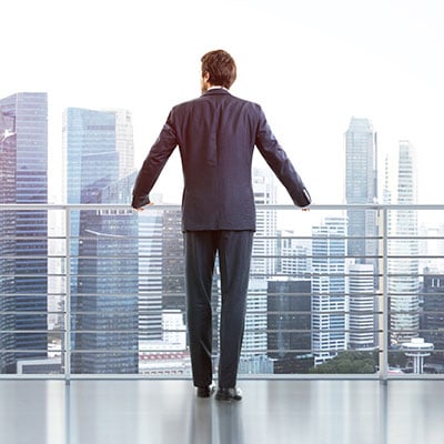 man-standing-on-balcony-looking-at-city