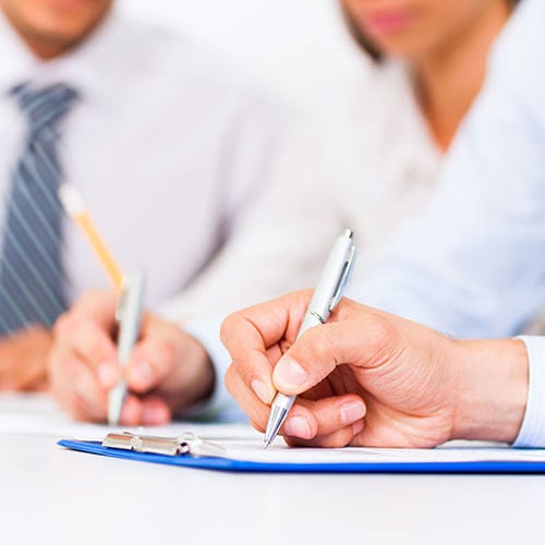 People writing at table