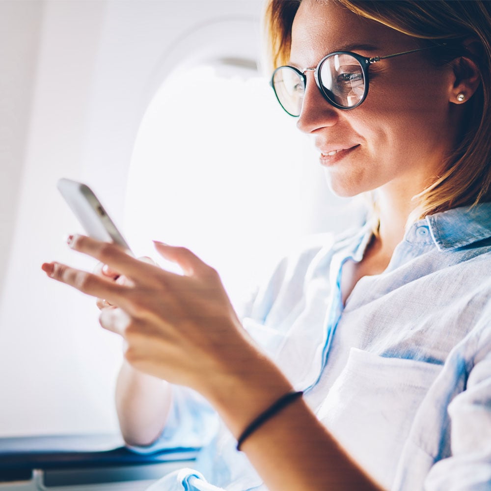 woman-on-flight-looking-at-phone