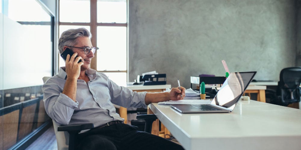 man-at-desk-on-phone_1000x500