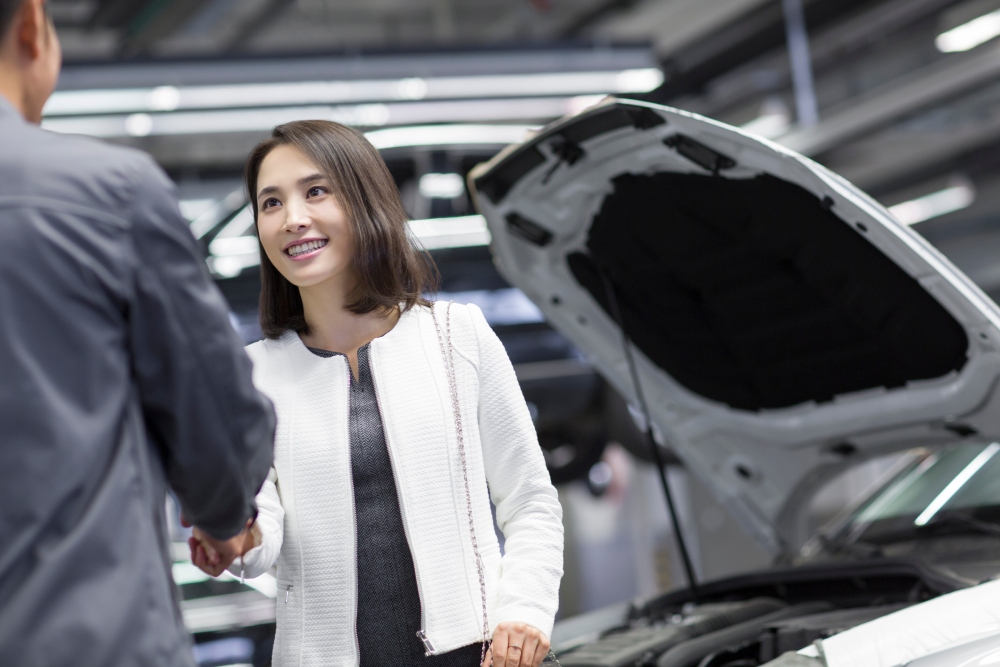 customer shaking hands beside serviced car