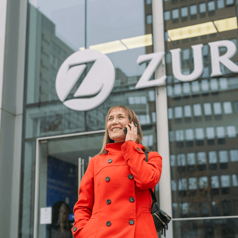 Zurich office entrance with Zurich signage and an employee speaking on a phone