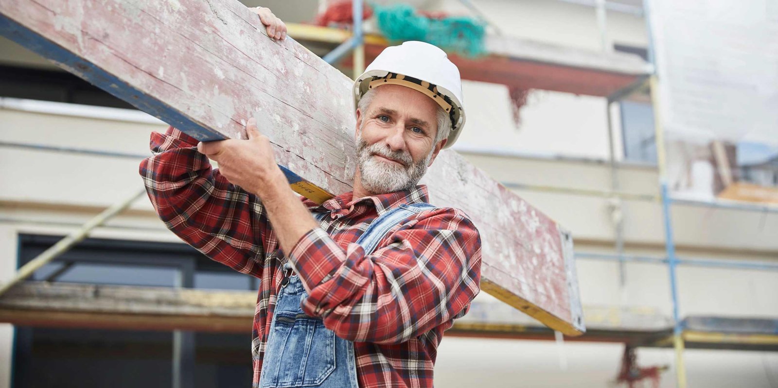 Älterer Mann hilft beim Hausbau