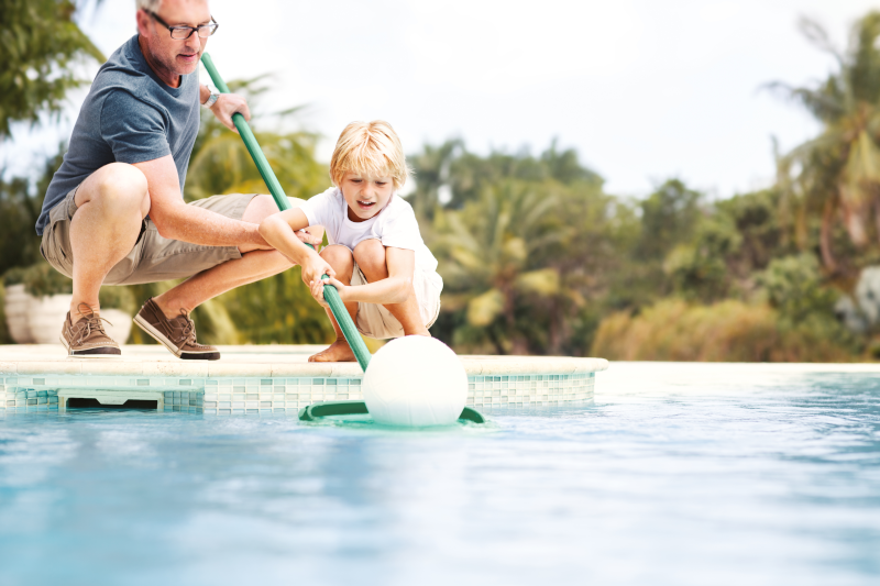 Mann und Kind fischen mit Kescher Schmutz aus einem Pool