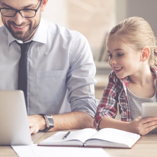 Father and daughter doing paperwork on laptop