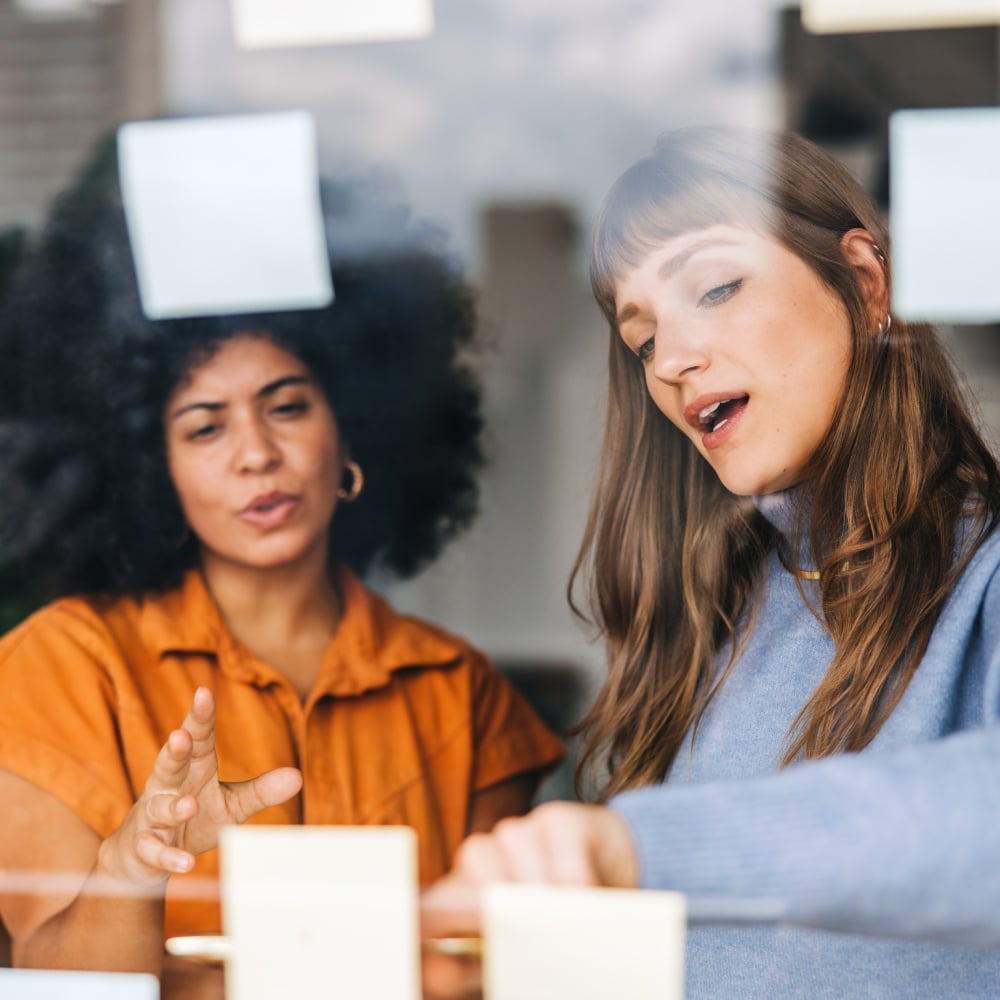 two women looking at some notes