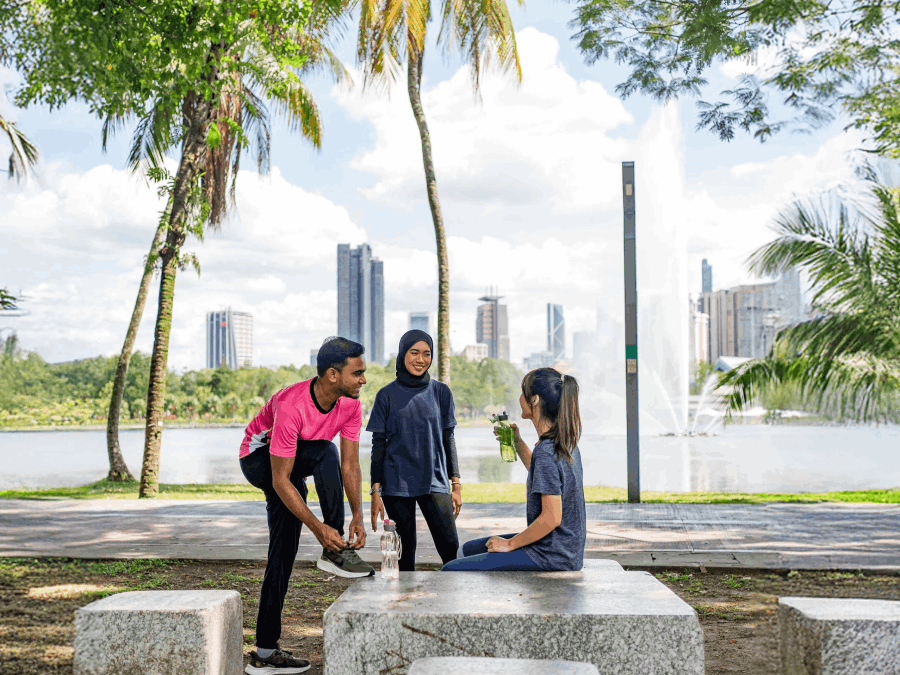 Group relaxing in park with city skyline.