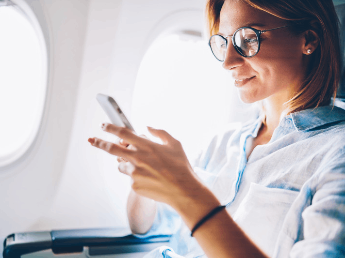 Person using a smartphone on an airplane.